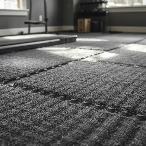 Dark grey rubber-backed interlocking carpet tiles installed in a home gym setting with exercise equipment.