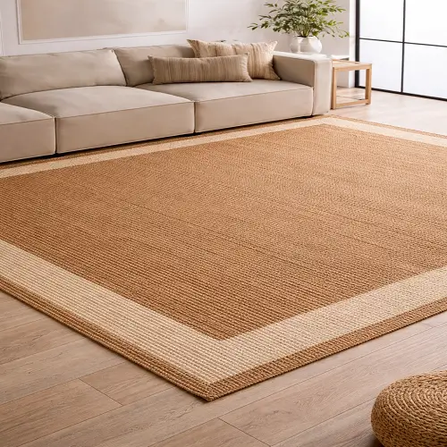 Flatweave jute carpet with a smooth, low-profile texture placed in a modern living room with a beige sofa and wooden flooring.