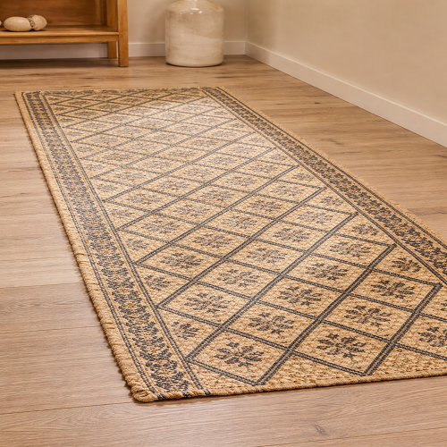 Patterned jute rug runner featuring intricate geometric and floral designs in natural beige and muted tones, placed on light wooden flooring in a minimalist interior for a warm and elegant look.