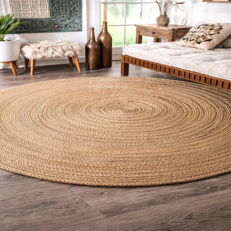Round braided jute carpet placed in a cozy bedroom setting with a wooden bed, soft cushions, and natural décor accents.