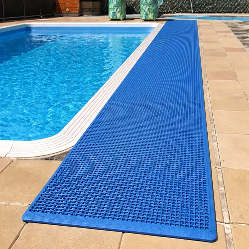 Blue anti-slip pool mat installed along the edge of a swimming pool, providing a safe walking surface and preventing slips on the wet poolside area.
